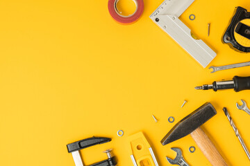 Handyman's tools. Flat lay of clamps, wrench, screwdriver, drill, angle, bubble level and tape measure on yellow background. Happy Father's Day. Free space  for you text