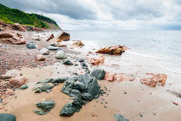 Scenic shoreline of Nova Scotia rocky beach, stormy weather, clouds, horizontal