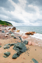 Scenic shoreline of Nova Scotia rocky beach, stormy weather, clouds, vertical