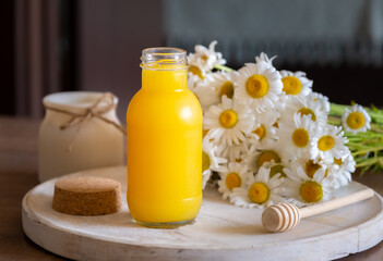 Fresh orange juice in small glass jar, chamomile on the background, healthy life concept, free...