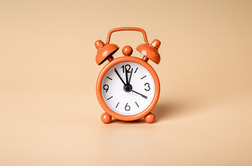 Retro styled bright orange alarm clock on background, photo