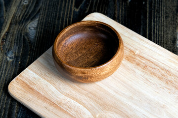 wooden plate on cutting board and black wooden table