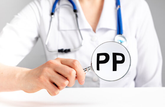 PP vitamin, word acronym through magnifying glass. High quality photo