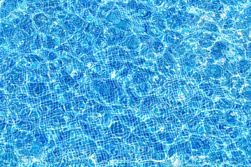 Surface of ripple blue water in swimming pool with reflection of sun. Swimming pool pattern.