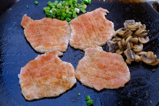 Fresh meat and mushrooms on metal saj.