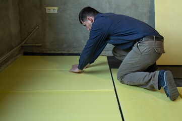 Installation of expanded polystyrene for floor insulation.