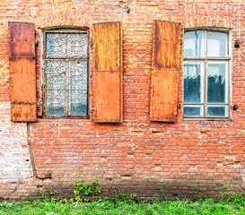 Fototapeta na wymiar Old building brick wall with an window with hinged shutters