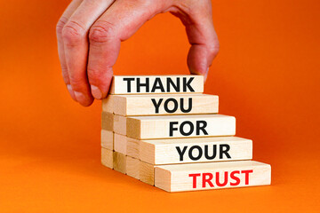 Thank you for trust symbol. Concept words Thank you for your trust on wooden blocks on a beautiful orange table orange background. Businessman hand. Business and thank you for trust concept.