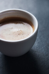 Cup of coffee on dark stone background. Close up. Copy space.	