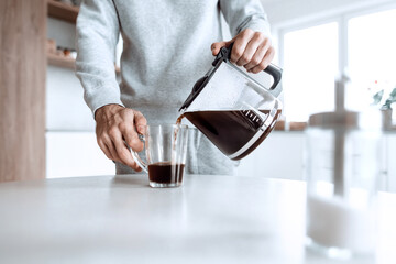 man pours himself a cup of coffee