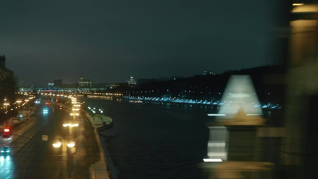 Train moving through night Moscow and crossing the bridge, window view
