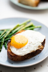 Fototapeta na wymiar Fried eggs with toasted bread and green asparagus. Fast lunch ideas, healthy breakfast, summer food.