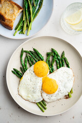 Fried eggs with green asparagus. Fast lunch ideas, healthy breakfast, summer food.