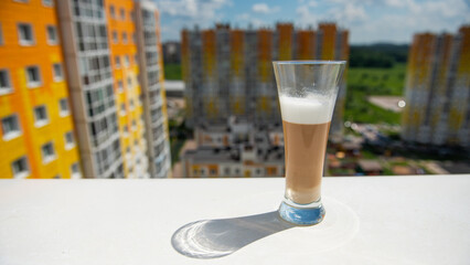 multilayer coffee on a white windowsill overlooking the city