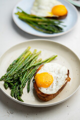 Fried eggs with toasted bread and green asparagus. Fast lunch ideas, healthy breakfast, summer food.
