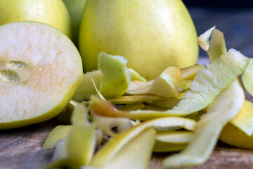 sliced and peeled green apple on a wooden board
