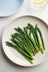 Grilled green asparagus on a a plate, top view.