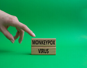 Monkeypox virus symbol. Concept word Monkeypox virus on wooden blocks. Beautiful green background. Doctor Hand. Medicine and Monkeypox virus concept. Copy space