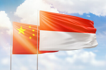 Sunny blue sky and flags of indonesia and china