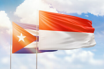 Sunny blue sky and flags of indonesia and cuba