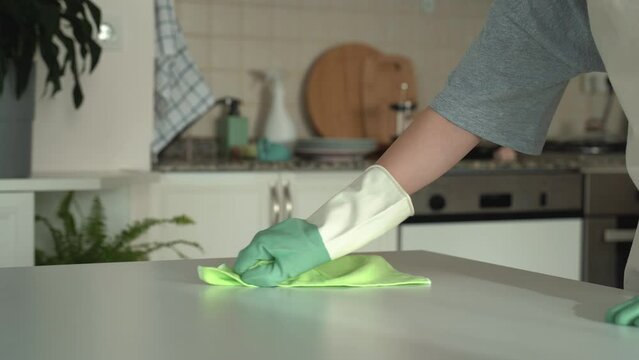 Hands of young woman wipes table with rag. housework and housekeeping concept. 4k footage.