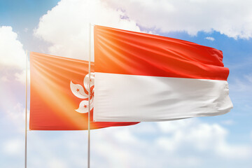 Sunny blue sky and flags of indonesia and hong kong