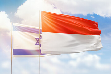 Sunny blue sky and flags of indonesia and israel