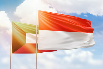 Sunny blue sky and flags of indonesia and kuwait