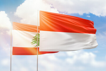 Sunny blue sky and flags of indonesia and lebanon