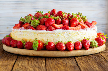 vanilla coconut cheesecake, decorated with fresh strawberries, a cup of aroma coffee on a table