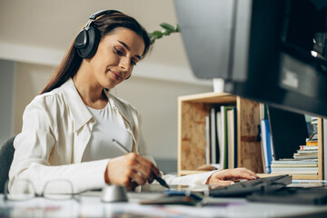 Young woman digital designer working on tablet and computer