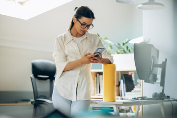 Female digital designer talking on the phone in an office