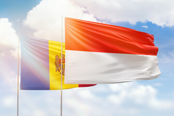 Sunny blue sky and flags of indonesia and moldova
