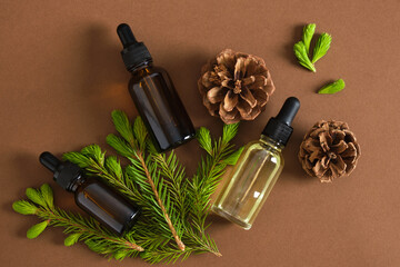 several glass dropper bottle with serum or oil and sprig of spruce with young shoots shoots