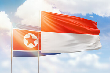 Sunny blue sky and flags of indonesia and north korea