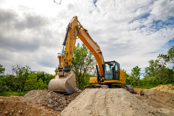 A stopping yellow excavator for rest, at a construction site