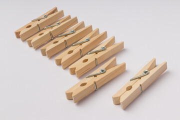 wooden clothespins lie in a row on a white background