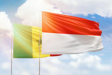 Sunny blue sky and flags of indonesia and senegal