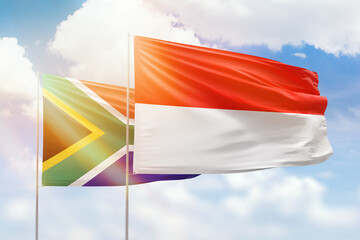 Sunny blue sky and flags of indonesia and south africa