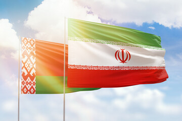 Sunny blue sky and flags of iran and belarus