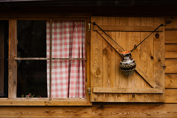 wooden house with wooden shutter and checker pattern curtains