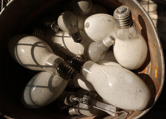 Old lightbulbs collection closeup in a waste bin