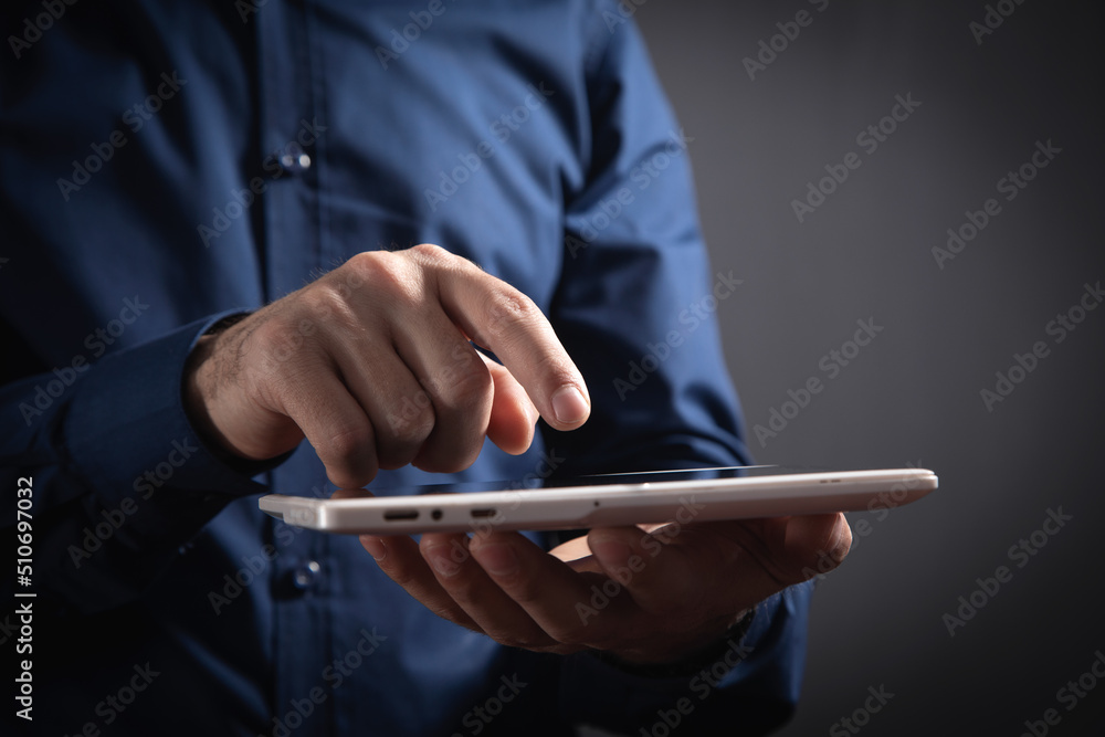 Wall mural businessman using white digital tablet.