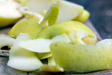 sliced and peeled green apple on a wooden board