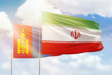 Sunny blue sky and flags of iran and mongolia