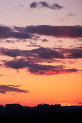 Dark clouds in the evening sunset sky with the setting sun. Dramatic sky during orange sunset