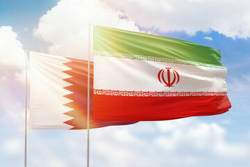Sunny blue sky and flags of iran and qatar