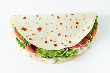 Italian street food flat lay with piadina isolated on a white background.  Piadina romagnola - Italian flatbread with prosciutto, salad and cream cheese