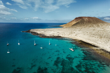 Vista aerea de playa en la isla de la graciosa islas canarias con mar turquesa y barcos