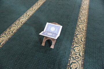 The Holy Qur’an on a wooden stand in the mosque, prayer and supplication in the mosque, worship...